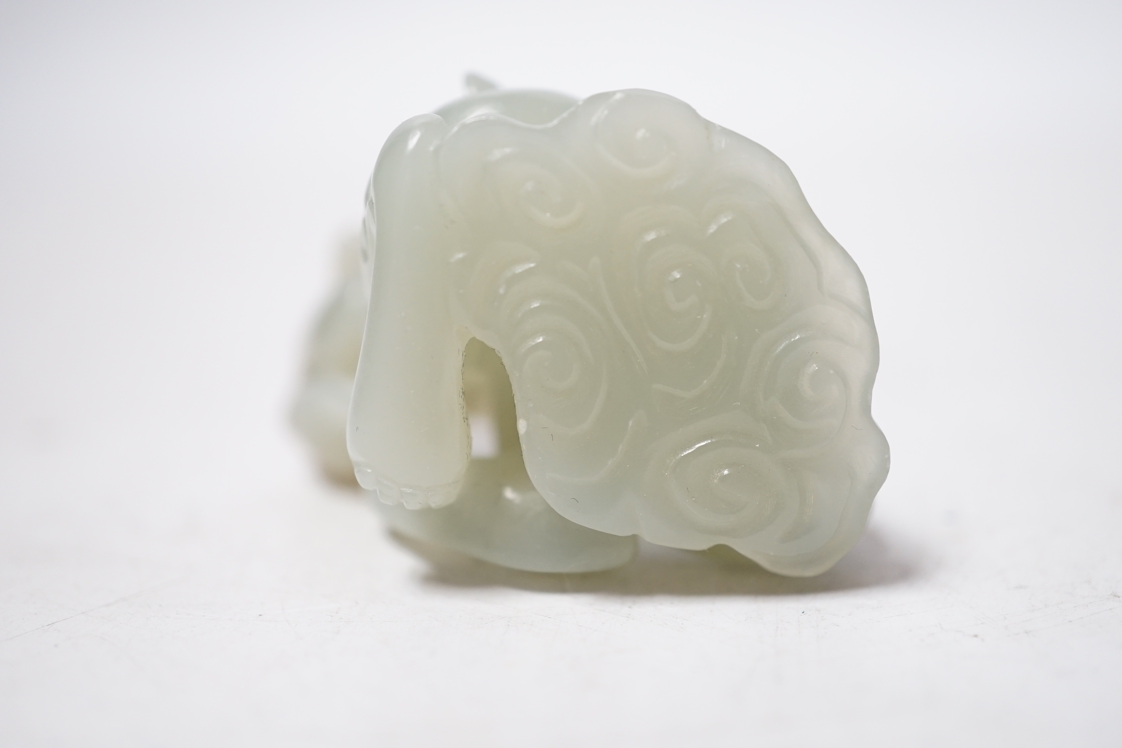 A Chinese pale celadon and russet skin jade figure of a dragon, 4cm high